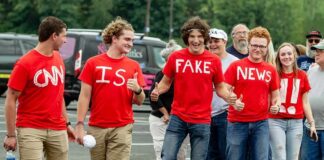 Group of young people in red shirts walking and giving thumbs up