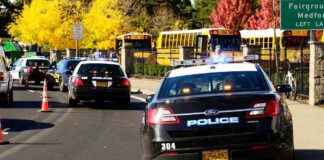 Children KILLED in Elementary School Shooting Police cars with lights on near school buses on a city street