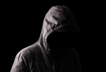 Stalker Must Warn Every Future DATE Hooded figure in shadow on black background