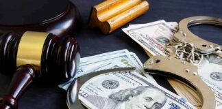 Gavel, handcuffs, and cash on a dark table