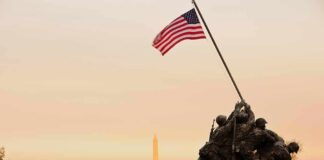 Iwo Jima Memorial with soldiers raising the American flag at sunset
