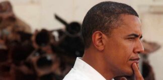 Barack Obama in profile, touching his chin thoughtfully