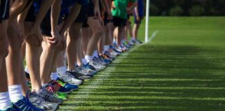 Runners lined up at a starting line on grass