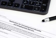 Unemployment benefits application form with keyboard and pen