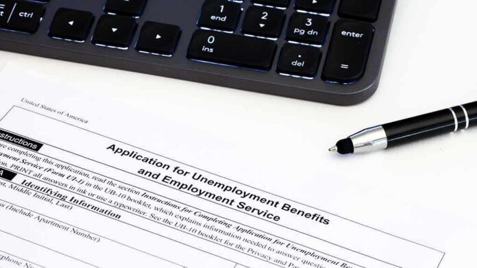 Unemployment benefits application form with keyboard and pen