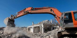 Excavator demolishing a concrete building