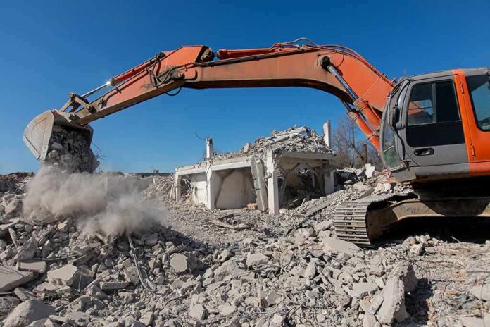 Excavator demolishing a concrete building