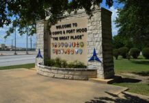 stone entrance sign with military unit emblems