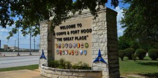 stone entrance sign with military unit emblems
