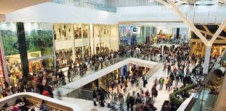 Crowded shopping mall interior with multiple levels