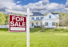 For sale sign in front of a suburban house