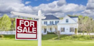 For sale sign in front of a suburban house
