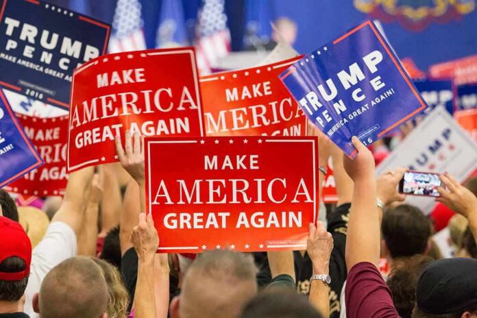 Crowd holding red and blue campaign signs at a political rally